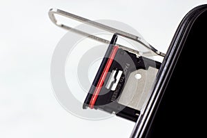 Pulling out the phone sim card tray from the smartphone with the help of edgector close up.