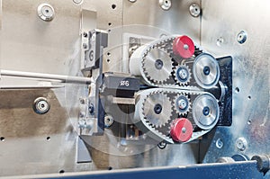 Pulling the wire through the gears on the machine. Part of industrial equipment at a modern plant. Side view