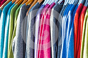 Pullovers hang on a hanger in the store, New Zealand. Close-up photo