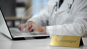 Pulmonologist prescribing medication to treat asthma, filling out medical forms