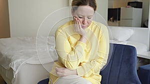 pulpitis, toothache, dental problems, a woman at home with a toothache holds her cheek with her hand