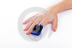 Pulse oximeter on a finger on white background.