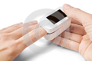 Pulse oximeter on finger of woman on white background