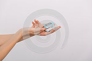 Pulse oximeter with hand of doctor isolated on white. Measuring oxygen saturation, pulse rate and oxygen levels. The