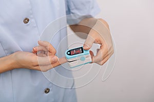 Pulse oximeter with hand of doctor isolated on white. Measuring oxygen saturation, pulse rate and oxygen levels. The