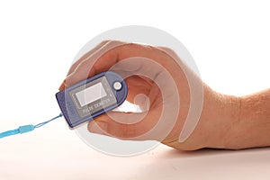 Pulse oximeter in human hand on a white background