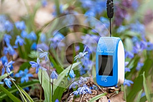 Pulse oximeter outdoors close-up in blue flowers