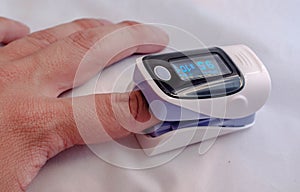Pulse oximeter on the patient's hand photo
