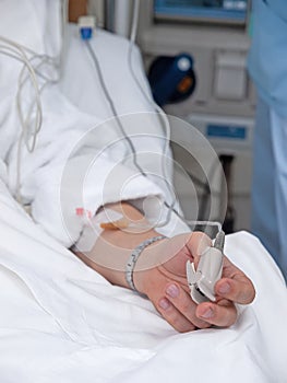 Pulse oximeter on the patient`s hand. Sugery equipment