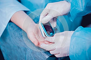 Pulse oximeter on the patient`s hand. Surgery equipment.