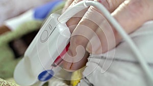 Pulse oximeter sensor at senior patient's finger