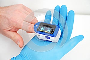 Pulse oximeter used to measure pulse rate and oxygen levels with hand