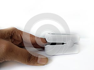 Pulse oximeter on white background. Close up of Finger and hand in an Oximeter Device.