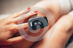 Pulse oximeter on woman`s left hand. Oxygen level and pulse measuring