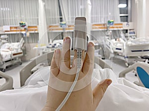 Pulse oximetry probe on a patient hand in intensive care unit photo