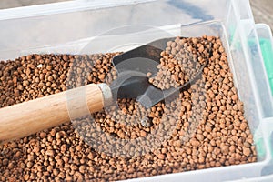 Pumice pebbles in bucket and gardening tool