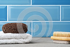 Pumice stone, brush and towel on shelf in bathroom