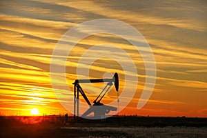 Pump jack in the oil field at sunset