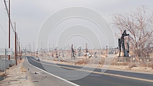 Pump jacks on oil field, USA. Rigs for crude fossil extraction on oilfield wells