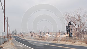 Pump jacks on oil field, USA. Rigs for crude fossil extraction on oilfield wells