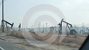 Pump jacks on oil field, USA. Rigs for crude fossil extraction on oilfield wells