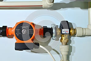 Pump with a thermometer for a water underfloor heating system at home. Sensor and temperature control. Manometer, pipe,