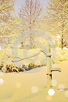 pump with water  well covered with snow  evening time  winter and snow