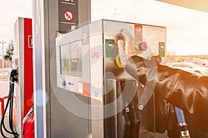 Pumping gas fuel car at oil station. Woman hand refuel petrol nozzle tank. Refueling transportation and Automotive