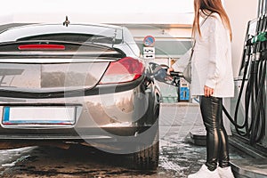 Pumping gas fuel car at oil station. Woman hand refuel petrol nozzle tank. Refueling transportation and Automotive industry