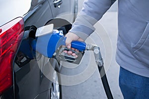 Pumping gas at gas pump. Closeup of man pumping gasoline fuel in