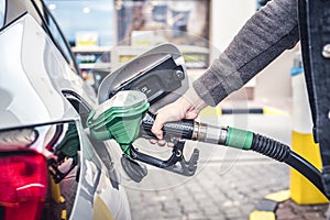 Pumping gas at pump. woman with handr efueling gasoline fuel in car at petrol station.