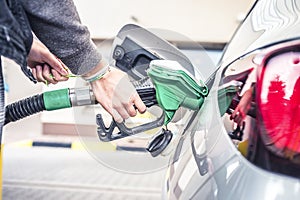 Pumping gas at pump. woman with handr efueling gasoline fuel in car at petrol station.