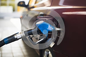 Pumping gasoline fuel in car at gas station