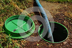Pumping out sewage from a septic tank. Pipe in the drainage pit