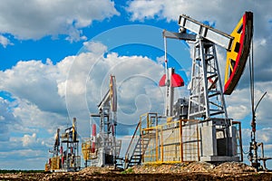 Pumping stations for oil and natural gas production against the cloud sky photo