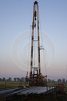 The pumping units and well workover operation. Oil Pump Jack Sucker Rod Beam and Workover Rig Working on Oil Well. Oil and gas photo