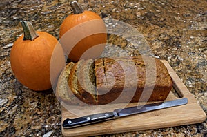 Pumpkin Bread cooling on wooden board with cutting knife