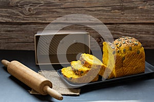 Pumpkin bread loaf sliced on black dish