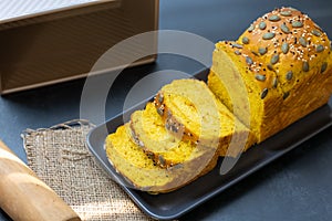 Pumpkin bread loaf sliced on black dish