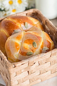 Pumpkin buns topping with pumpkin seeds in the basket.