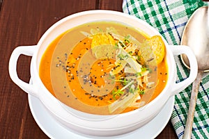 Pumpkin carrot cream soup with parmesan and green shoots of watercress