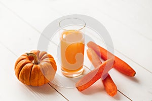 Pumpkin and Carrot smoothie in white wooden background. close-up view of natural fresh smoothies in glasses and ingredients on