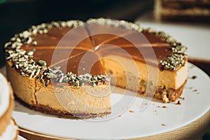 Pumpkin cheesecake with fall spices topped with pumpkin seeds, close up.