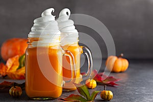 Pumpkin  cocktail with whipped cream in glass mugs. Pumpkin autumn drink for Halloween or Thanksgiving