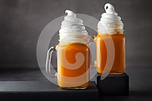 Pumpkin  cocktail with whipped cream in glass mugs. Pumpkin autumn drink for Halloween or Thanksgiving