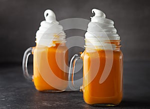 Pumpkin  cocktail with whipped cream in glass mugs. Pumpkin autumn drink for Halloween or Thanksgiving