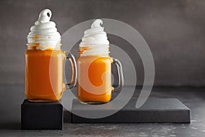 Pumpkin  cocktail with whipped cream in glass mugs. Pumpkin autumn drink for Halloween or Thanksgiving