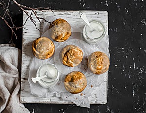 Pumpkin and cream cheese swirl muffins and greek yogurt. Delicious breakfast or snack. On a dark background, top view.