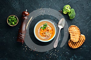 Pumpkin cream soup in a bowl, with toast bread. Dietary food. Top view.