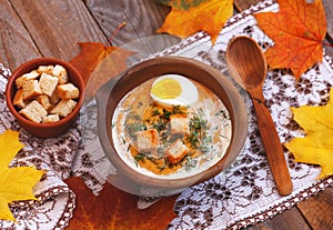 Pumpkin cream-soup decorated with maple leaves, boiled egg and c